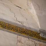 Lungo tutto il perimetro corre un decoro a fascia con forme circolari continue dai toni blu e ocra...